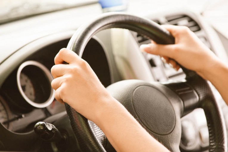 Wheel of car from hand of driver.