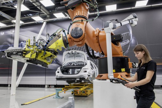 2016 Mercedes-Benz E-Class body Lissy Brückner, Process Engineer, installing the battery into a hybrid vehicle. Using Man-Robot Cooperation (MRC) and a driverless transport vehicle (DTV), the operation is more flexible