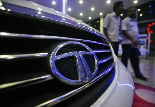 Men walk inside a Tata Motors showroom on the outskirts of Agartala