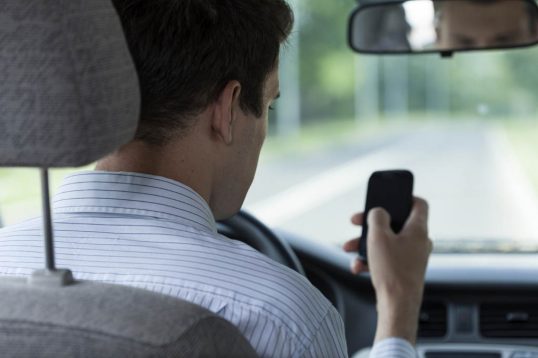 Horizontal view of driver using mobile phone
