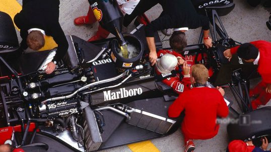 alain-prost-sits-in-his-mclaren-mp4-3-tag-porsche-while-the-mechanics-get-to-work-on-the-car-and-refuel