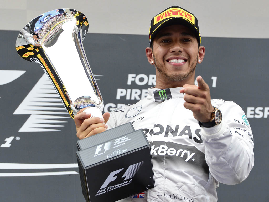 Mercedes-AMG's British driver Lewis Hamilton celebrates on the podium